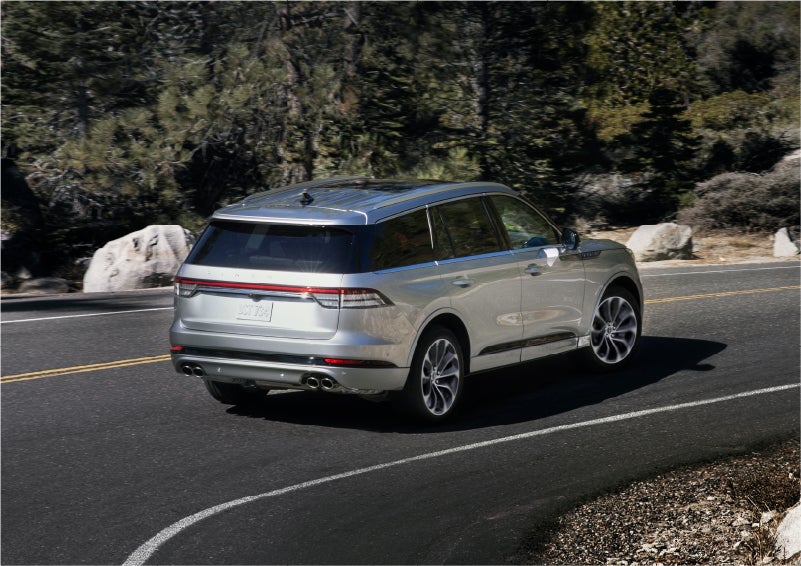 A 2023 Lincoln Aviator® Grand Touring model is shown being driven on a tight turn of a mountain road | Beach Lincoln in Myrtle Beach SC