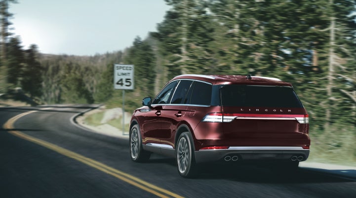 A 2024 Lincoln Aviator® SUV is being driven on a winding mountain road | Beach Lincoln in Myrtle Beach SC