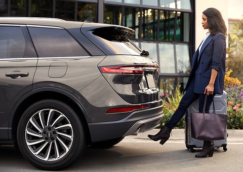 A woman with her hands full uses her foot to activate the available hands-free liftgate. | Beach Lincoln in Myrtle Beach SC