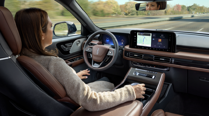A woman is seen sitting in the driver’s seat of her 2025 Lincoln Aviator® SUV with her hands off the steering wheel. | Beach Lincoln in Myrtle Beach SC