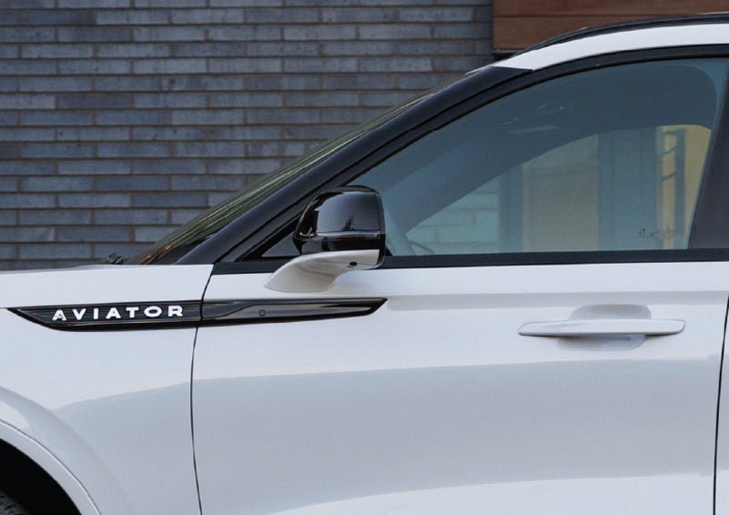 The driver’s side door and fender badging of a white 2026 Lincoln Aviator® SUV are showcased. | Beach Lincoln in Myrtle Beach SC